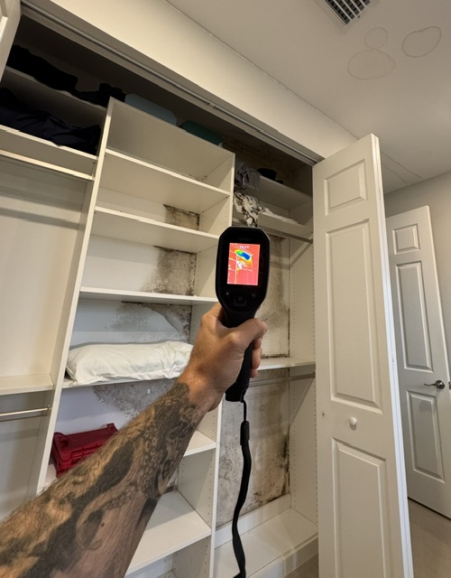 Giza Roofing Solutions inspector using a handheld thermal imaging camera to identify moisture damage